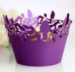 Purple laser-cut cupcake wrappers with elegant bird and branch patterns for party decor