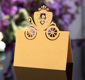 Macro detail of gold laser-cut pumpkin carriage place card with reflective finish