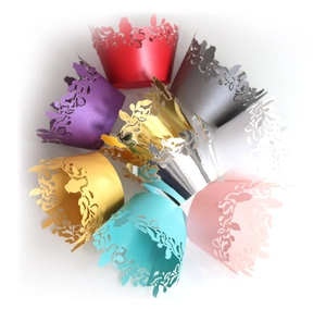 Detailed laser-cut bird cupcake wrappers in various pearlized colors for wedding decor