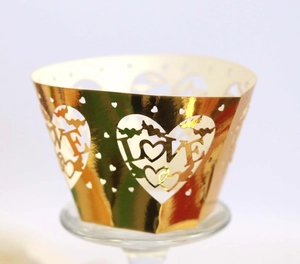 Detailed laser-cut gold cupcake wrapper featuring LOVE letters and heart shapes