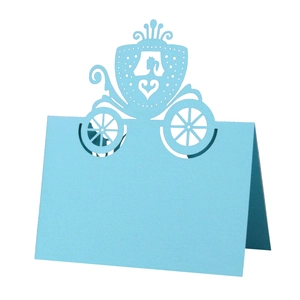 Detail of light blue laser-cut place card featuring a delicate pumpkin carriage design