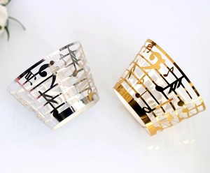 Macro detail of laser-cut musical notes on gold and silver cupcake wrappers