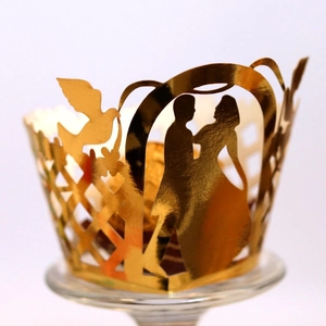 Laser cut gold cupcake wrappers featuring bride and groom silhouette for wedding decor
