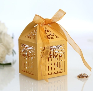 Detail of laser-cut floral fence gift box with a sheer gold ribbon and pearl finish