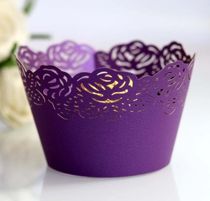 Close-up of purple laser-cut cupcake wrapper with elegant hollow rose flower pattern