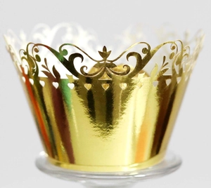 Detail of laser-cut gold crown lace cupcake wrapper with heart hollow pattern