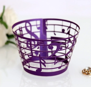 Macro detail of laser-cut purple cupcake wrapper featuring music notes and staff patterns