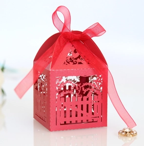 Detail of red hollowed-out candy box with laser-cut patterns and ribbon bow
