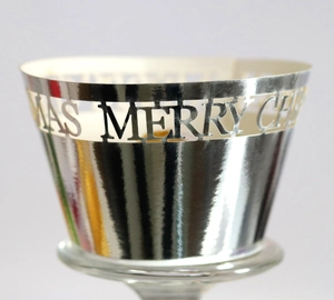 Macro detail of Merry Christmas hollow silver metal cake wrapper with mirror finish