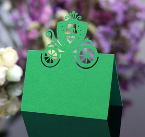 Macro view of green laser-cut place card with a Cinderella carriage design