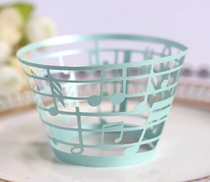 Macro view of laser-cut musical note patterns on mint blue cupcake paper wrappers