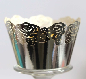 Macro shot of laser-cut rose hollow cupcake wrappers with a shiny silver metallic finish