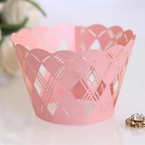 Pink laser-cut cupcake wrappers with hollow diamond pattern and elegant wavy edges