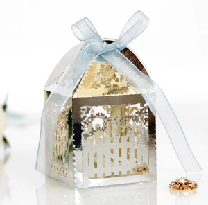 Detailed laser-cut fence style favor box with intricate hollow patterns and blue ribbon