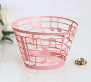 Macro shot of laser-cut pink musical note cupcake wrappers with pearlescent finish