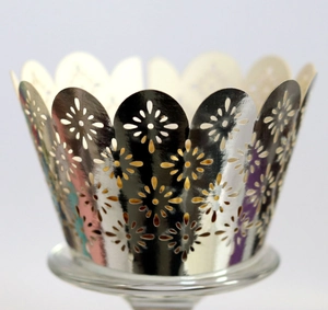 Detail of silver laser-cut cupcake wrapper featuring floral patterns and scalloped edges