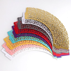 Laser-cut pearl paper cupcake liners with intricate floral patterns in assorted colors