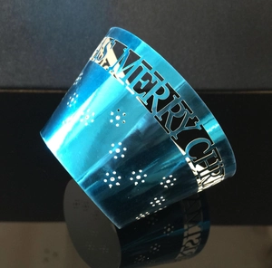 Detail view of Merry Christmas laser cut lettering on blue metallic cupcake wrapper