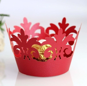 Close-up of red laser-cut crown pattern cupcake wrapper with a chocolate inside