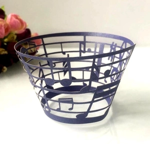 Close-up of purple laser-cut musical note cupcake wrapper with intricate staff line details