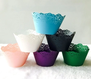 Macro shot of assorted color laser-cut rose hollow cupcake wrappers in pearl paper