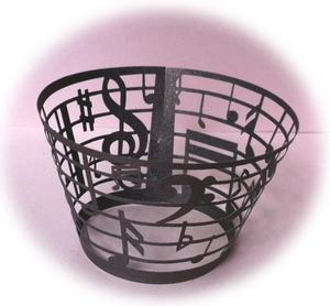 Detail showing the intricate laser-cut musical notes on a matte black metal basket