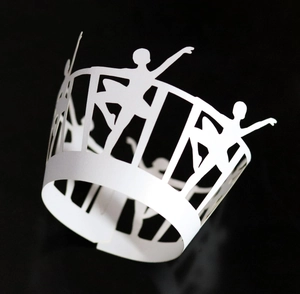 Macro detail of laser cut white cupcake wrappers featuring dancing ballet girl silhouettes