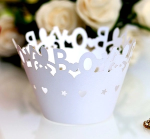 Detailed laser-cut white cupcake wrappers with BOY lettering and star heart patterns