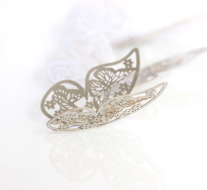 Detailed macro view of laser-cut hollow silver 3D butterfly wall stickers for living room decor