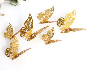 Detail of 3D gold hollow butterflies with laser-cut floral patterns for wall decor
