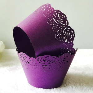 Deep purple laser-cut cupcake wrappers with intricate rose patterns and lace texture