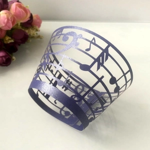 Purple laser-cut musical note cupcake wrappers with staff and clef pattern decorations