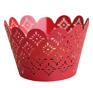Red laser-cut cupcake wrappers with floral patterns and scalloped edges for festive baking