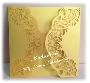 Laser cut pearlescent paper wedding invitation with intricate symmetrical floral pattern
