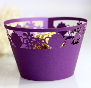 Close-up of laser-cut purple cupcake wrapper with teapot floral patterns and chocolate