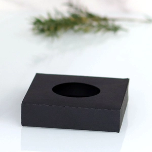 Detail of matte black paper candle base with circular cutout for wedding decor