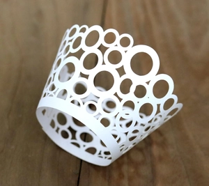 Laser cut white cupcake wrappers with circular hollow pattern for wedding party decoration