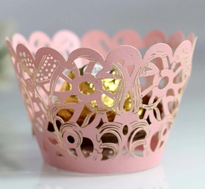 Pink laser-cut lace cupcake wrapper with intricate floral hollow design for party decor