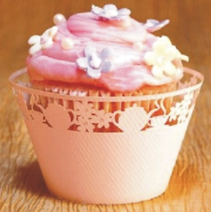 Detail of pink laser-cut cupcake wrapper with teapot and floral patterns for tea parties