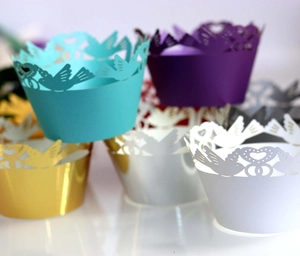 Laser-cut cupcake wrappers with bird and heart patterns in multiple metallic colors