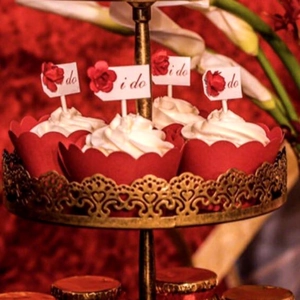 Red laser cut cupcake wrappers with I Do rose toppers for wedding dessert table decor
