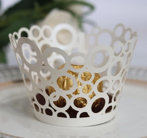 Lace laser-cut cupcake wrappers with white circle pattern around chocolate ball