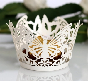 Detailed macro view of laser-cut ivory butterfly paper cupcake and chocolate wrapper