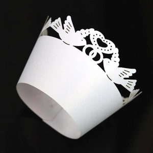 Macro detail of laser-cut pearl white cake wrapper with heart bird pattern design