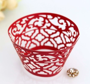 Detailed laser-cut lace pattern on red pearlescent paper cupcake wrapper for weddings