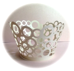 Macro detail of laser-cut geometric patterns on pearl white cupcake liners for weddings