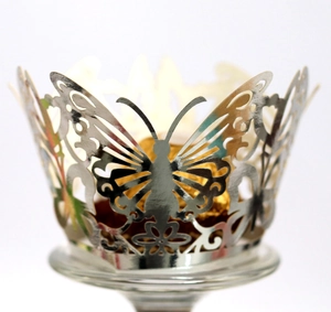 Silver laser-cut butterfly cupcake wrapper with intricate patterns for party favors