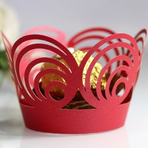 Red laser-cut cupcake wrappers with intricate hollow patterns for wedding cake decoration
