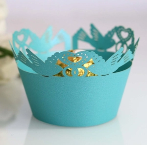 Detail of light blue laser-cut cupcake wrapper with bird and heart hollow patterns