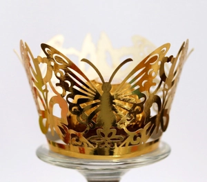 Laser-cut gold butterfly cupcake wrapper with intricate hollow patterns for wedding decor